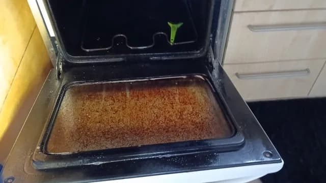 An oven door with baked-on residue before cleaning